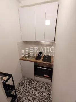 Small kitchen with white cabinets and built-in appliances. - image 5
