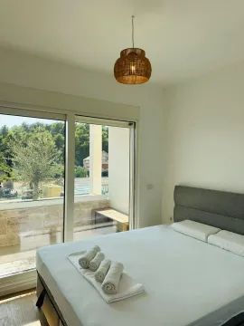 Svijetla spavaća soba sa bračnim krevetom i velikim balkonskim vratima. - image 7