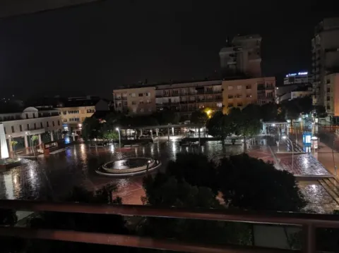 Night view from the terrace overlooking the illuminated town square and fountain. - image 8