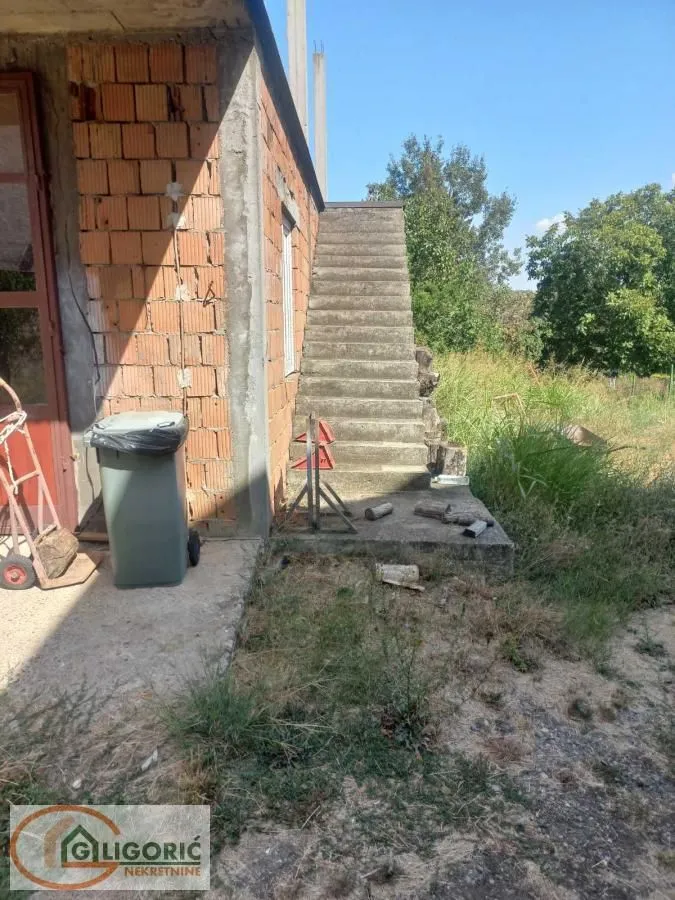 Exterior view of a house under construction with concrete stairs.