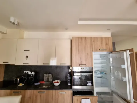 Moderna kuhinja sa drvenim i bež elementima i ugrađenim aparatima. - image 5