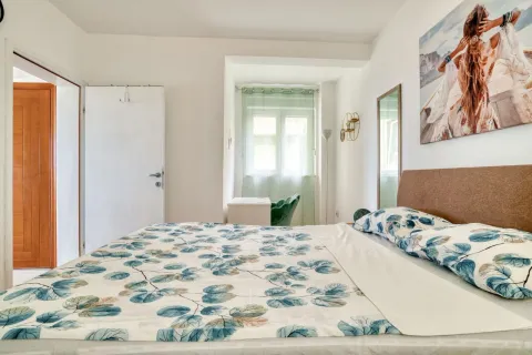 Furnished bedroom with a double bed, window, and wall art. - image 13