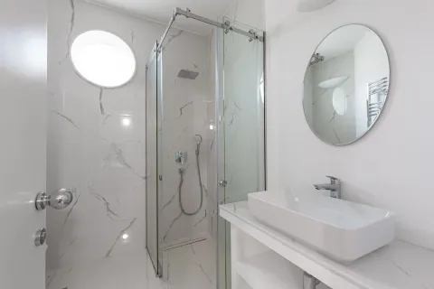 Moderne kupatilo sa tuš kabinom, umivaonikom i okruglim ogledalom. - image 62