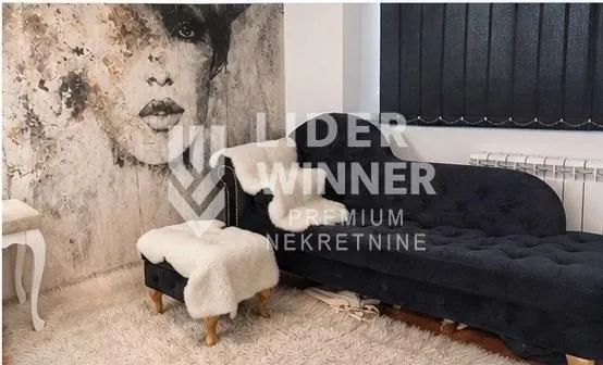 Living room with a black upholstered sofa and a large wall art painting.