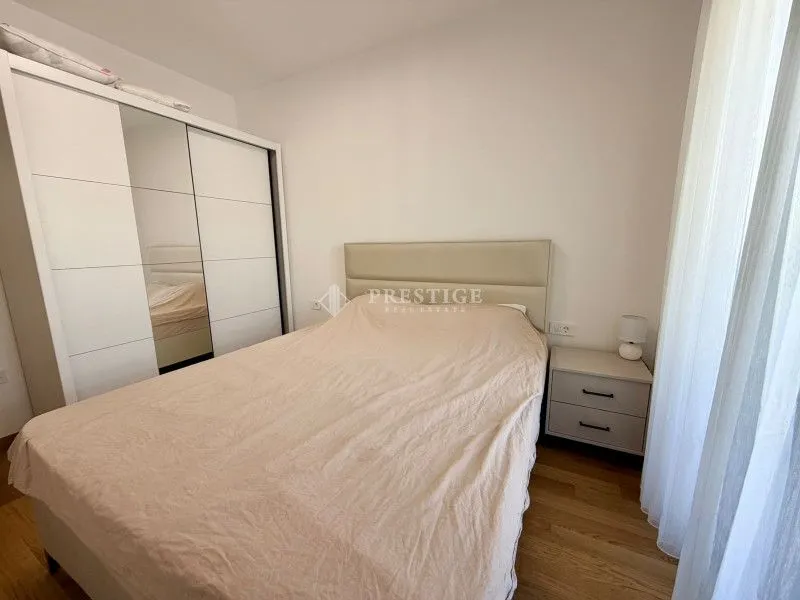 Spavaća soba sa bračnim krevetom, garderoberom i noćnim stočićem.