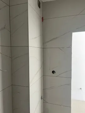 Bathroom during final ceramic tile installation. - image 4