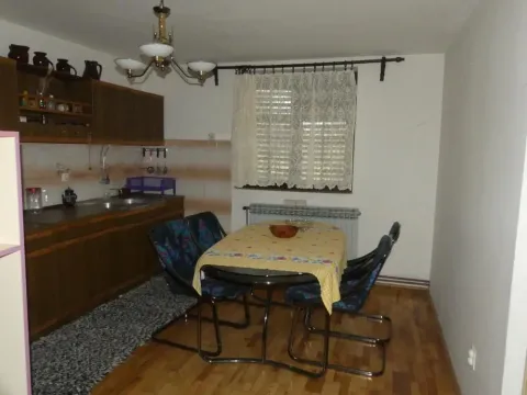 Kitchen with wooden units and a dining table with chairs. - image 20
