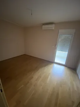 Prazna soba sa parketom, klima uređajem i izlazom na terasu. - image 11