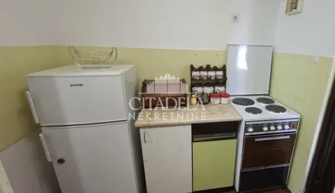 Small kitchen with a refrigerator, stove, and basic kitchen units. - image 7