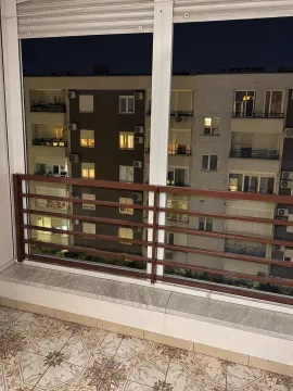 Pogled sa zastakljene terase na okolne zgrade u večernjim satima. - image 4