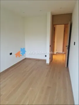 Empty room with hardwood flooring and an open door leading to the hallway. - image 9