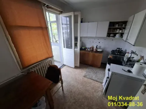 Small kitchen with white cabinets and access to the balcony. - image 5