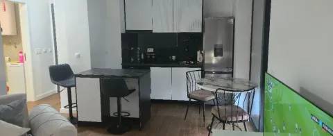 Modern kitchen with a breakfast bar and dining table connected to the living room. - image 2