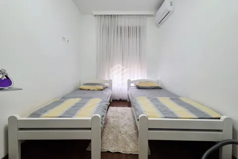 Bedroom with two single beds and white walls. - image 8