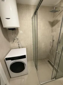 Moderno opremljeno kupatilo sa tuš kabinom i veš mašinom. - image 7