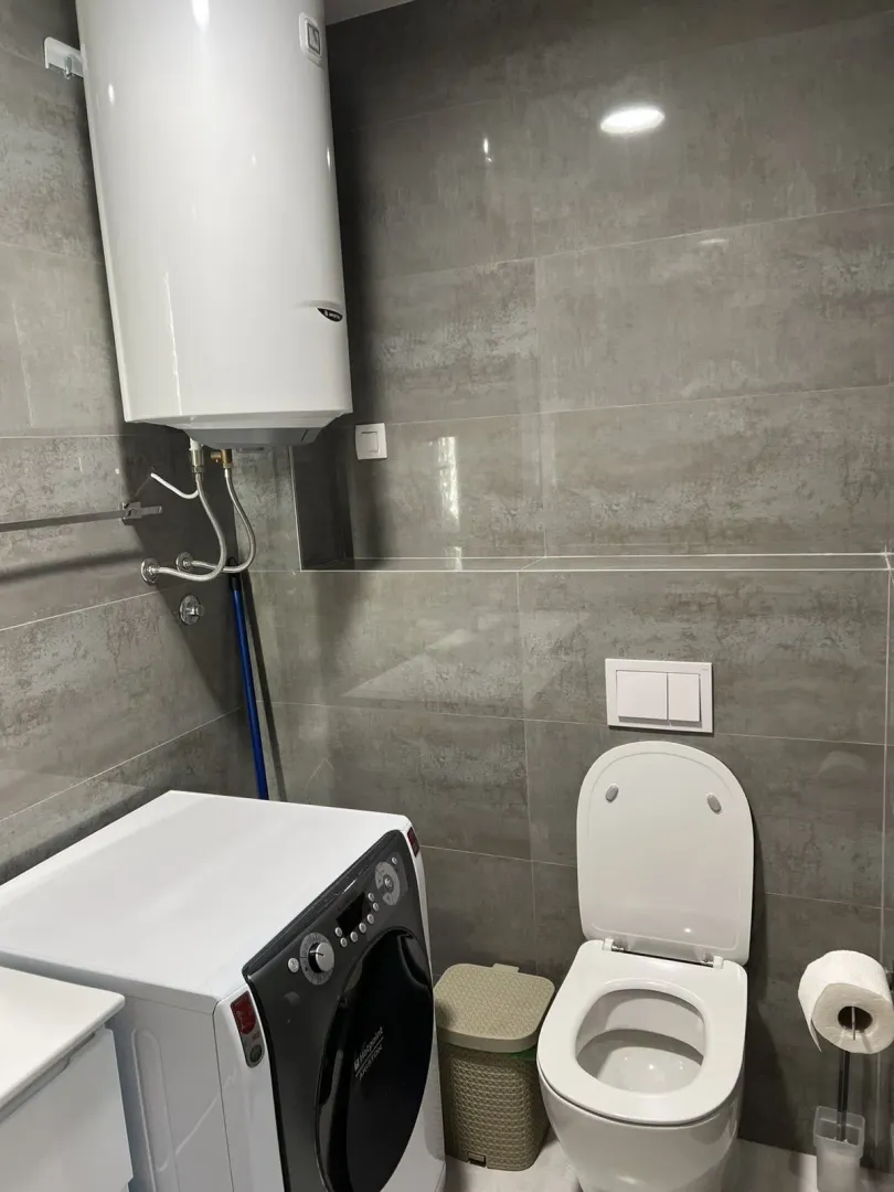 Moderno kupatilo sa veš mašinom i bojlerom.