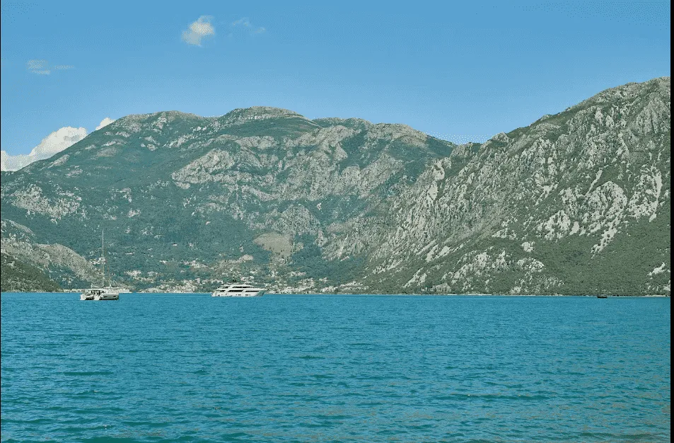Pogled na more i planine sa jahtama u zalivu.