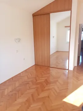 An empty room with light parquet flooring and a built-in wardrobe with a mirror. - image 29