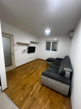 Dnevna soba sa garniturom, parketom i televizorom na zidu. - image 8