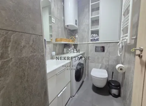 Modern bathroom with a walk-in shower, washbasin, and washing machine. - image 9