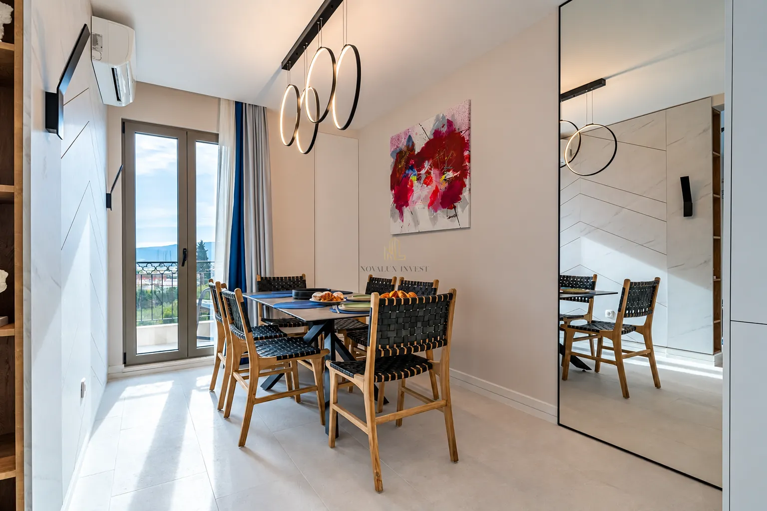 Dining area with a table, chairs, and modern pendant lights.