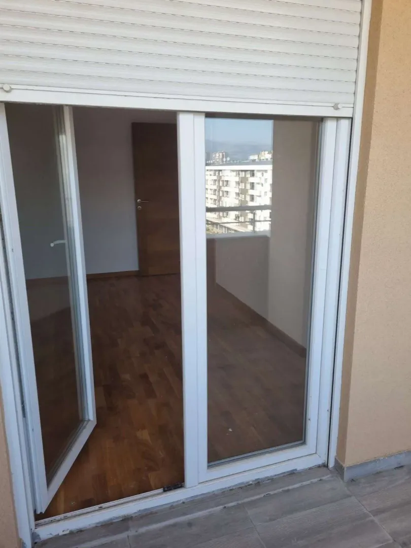 Pogled sa terase na praznu sobu kroz otvorena balkonska vrata.