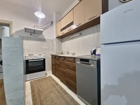 Small kitchen with wooden cabinets, stove, and refrigerator. - image 3