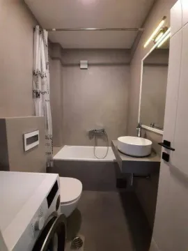 Savremeno opremljeno kupatilo sa kadom, umivaonikom i mašinom za veš. - image 17