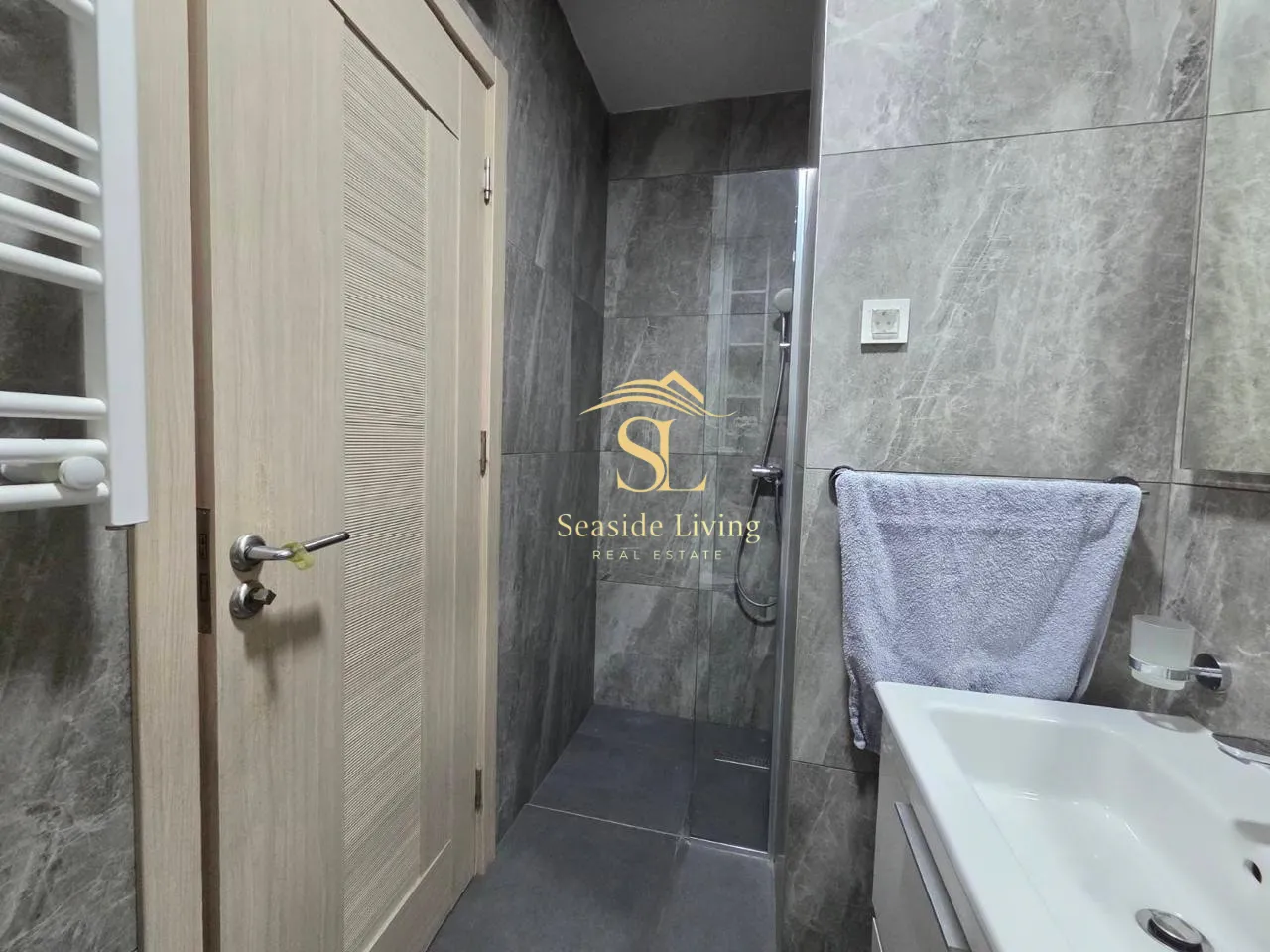 Modernly equipped bathroom with a shower cabin and washbasin.