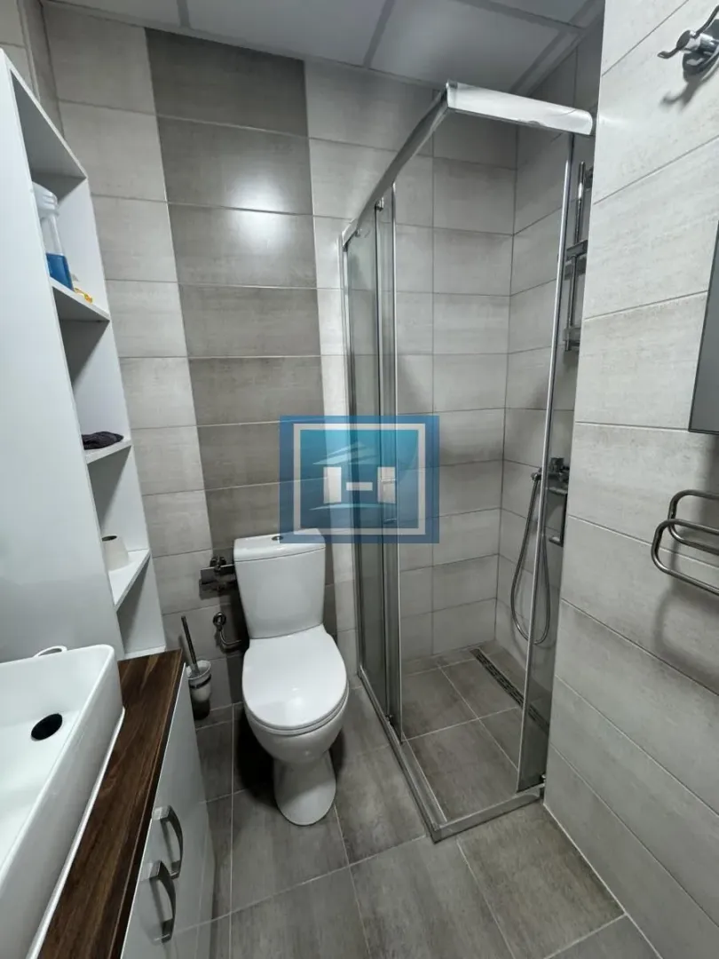Moderno kupatilo sa tuš kabinom, WC šoljom i umivaonikom.