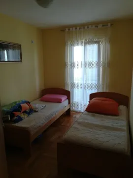 A simple bedroom with two single beds. - image 6