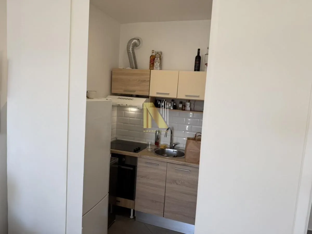 Smaller kitchen with wooden units and basic appliances.