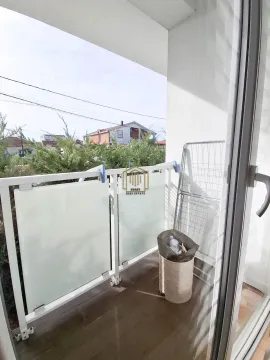 Manji svijetli balkon sa ogradom i pogledom na okolno zelenilo. - image 12