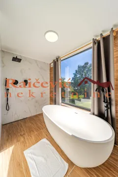 Moderno kupatilo sa samostojećom kadom i tuš kabinom pored velikog prozora. - image 19