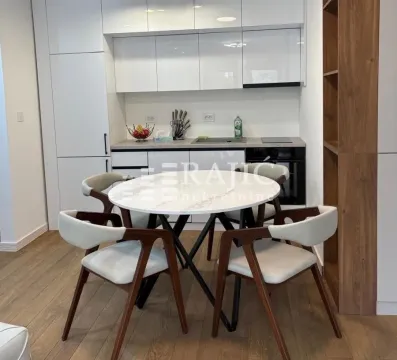 Dining area with a round table and modern chairs as part of the kitchen. - image 2