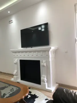 Living room with a decorative fireplace and wall-mounted TV. - image 13