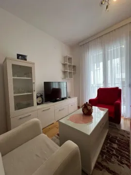 Living room with seating furniture, TV unit, and display cabinet. - image 5
