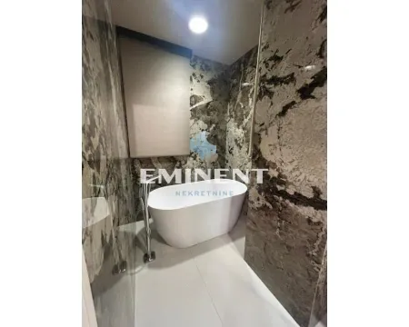 Modern bathroom with a freestanding bathtub and marble-look tiles. - image 10