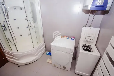 Bathroom with a shower cabin, washing and drying machine, and a water heater. - image 4
