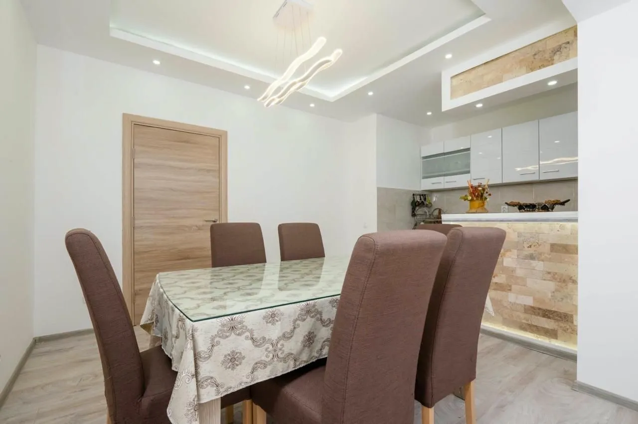Modern dining area with a table and chairs, connected to the kitchen.