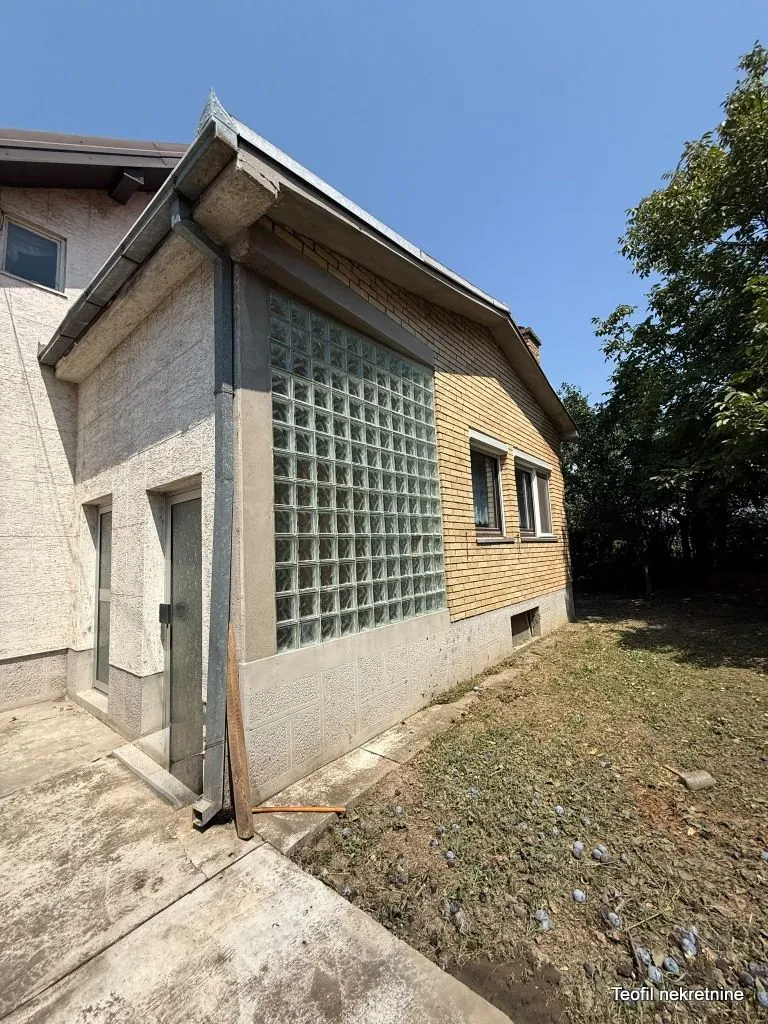 Pogled na spoljašnjost kuće sa dvorištem i fasadom.