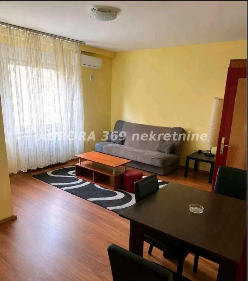 Dnevna soba sa garniturom, stočićem i trpezarijskim stolom.