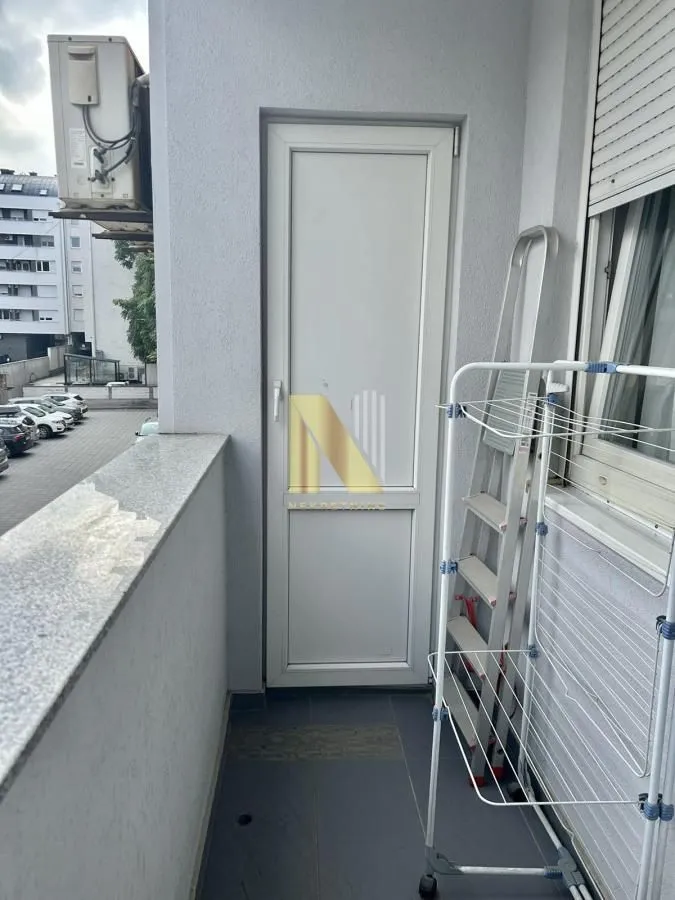 Manji balkon sa vrata, sušilicom za veš i klima uređajem.