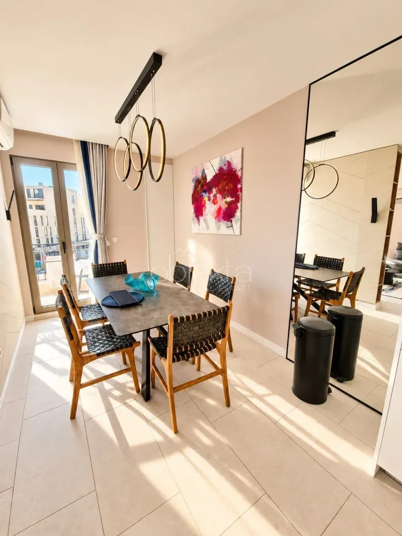 Dining area with a dining table, chairs, and a large wall mirror.