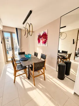 Dining area with a dining table, chairs, and a large wall mirror. - image 9