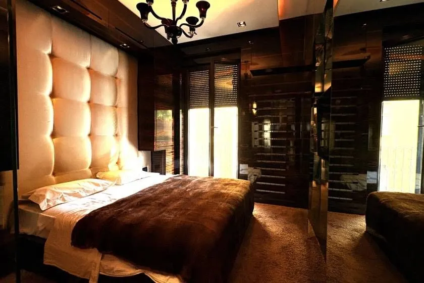 Luxuriously furnished bedroom with a large double bed and a cushioned headboard.