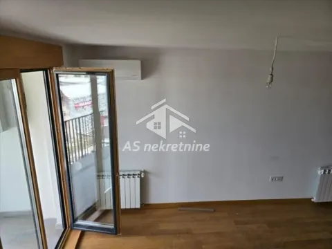 Empty room with wooden flooring, radiator, and balcony access. - image 3