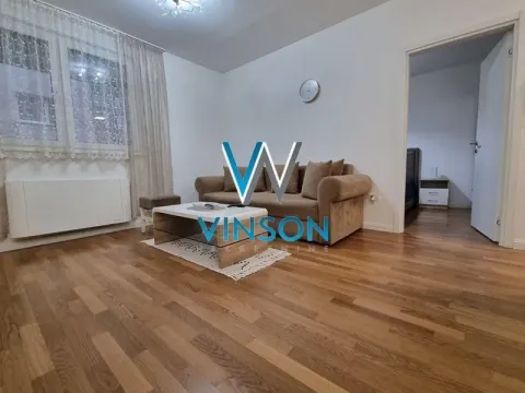Dnevna soba sa garniturom za sedenje i drvenim podom. - image 3