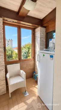 Zastakljeni balkon sa drvenom stolarijom, frižiderom i pogledom na zelenilo. - image 5