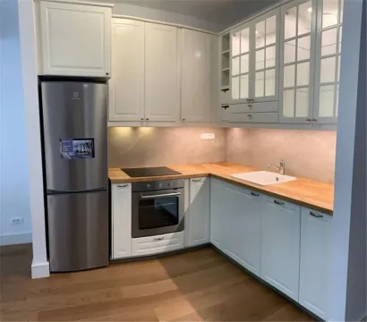Kitchen with white cabinets, wooden countertop and refrigerator. - image 5